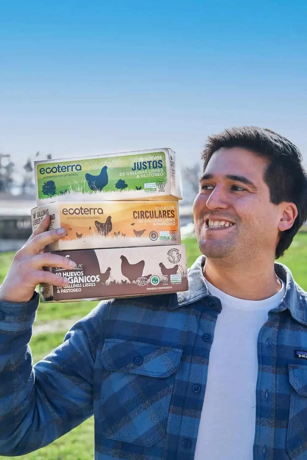 Productor agrícola con empaques de 10 huevos orgánicos, justos y circulares de gallinas libres a pastoreo Ecoterra con certificación Certified Humane.
