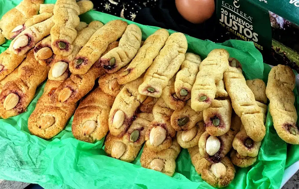 Galletas de dedos de bruja para Halloween elaboradas con huevos de gallinas libres a pastoreo Ecoterra y almendras, presentadas junto al empaque de 20 Huevos Justos.