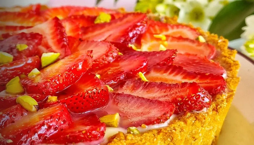 Tartaleta de frutillas frescas laminadas sobre crema pastelera dorada y masa crujiente elaborada con huevos de gallinas libres y mantequilla de pastoreo Ecoterra.