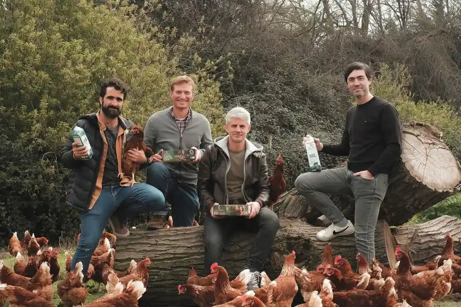 Equipo de Ecoterra y productores EcoFarmers en la pradera con gallinas libres a pastoreo, huevos y leche, destacando la trazabilidad por blockchain y el comercio justo en Chile.