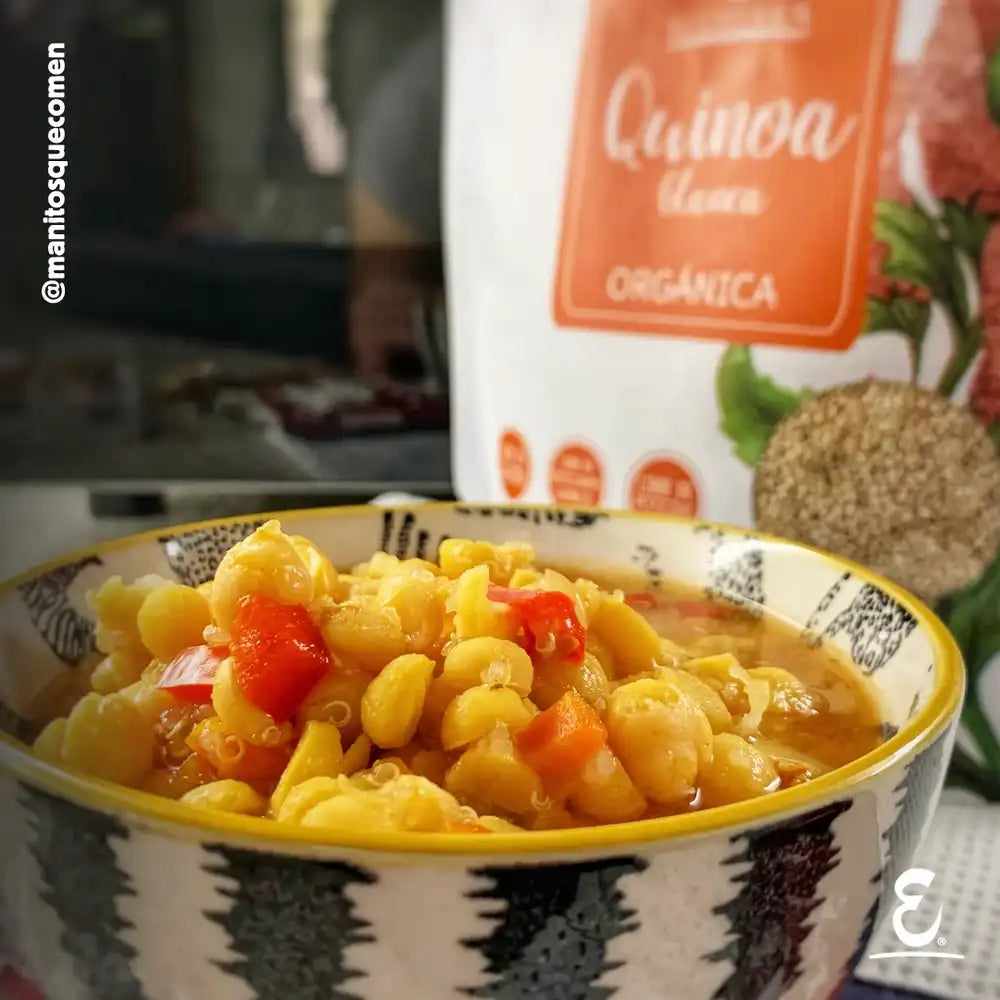Receta de Guiso casero de garbanzos con pimentón rojo y quinoa blanca orgánica Ecoterra servido en un tazón decorado junto al empaque de quinoa orgánica.